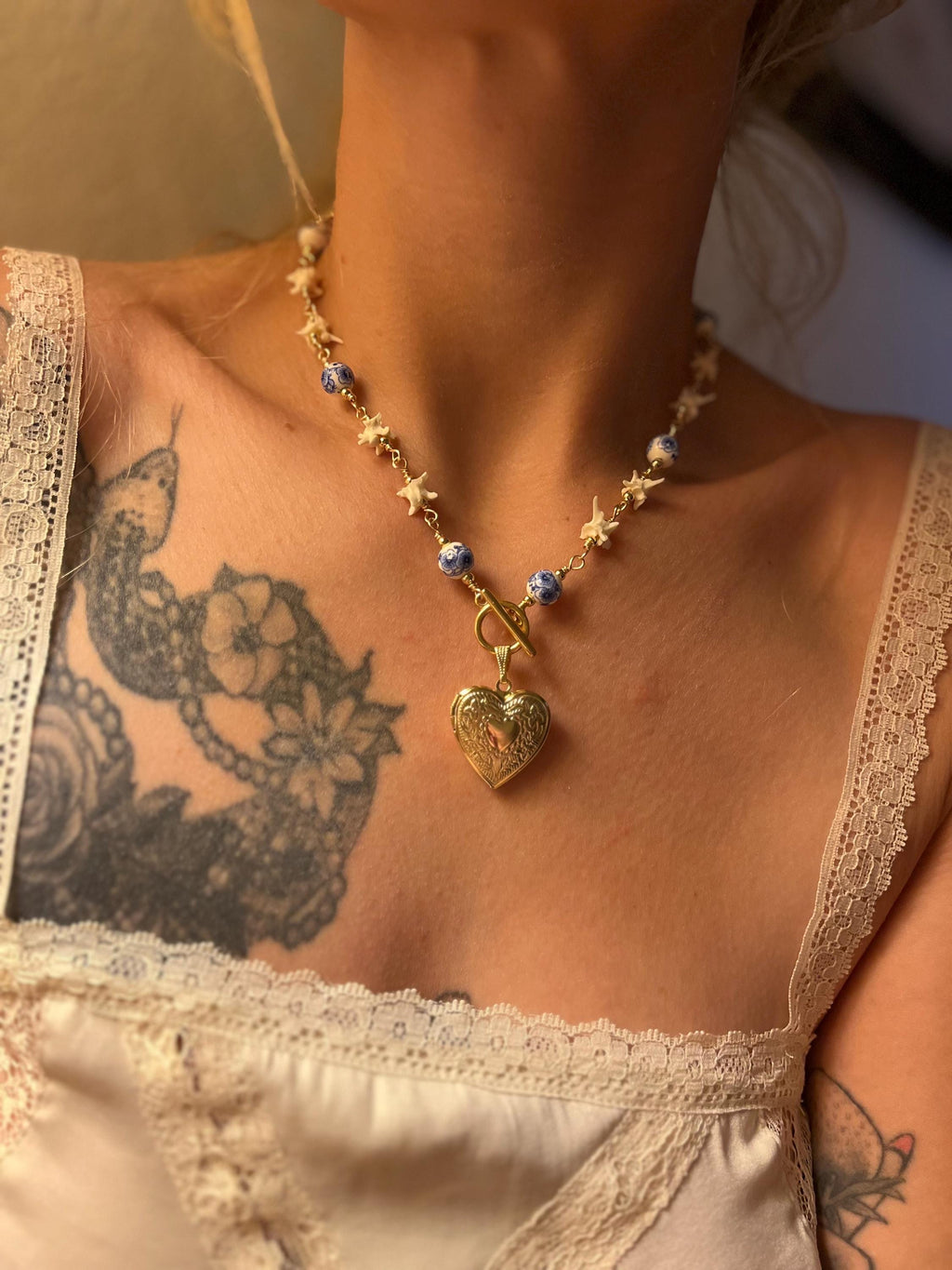 Rattlesnake Vertebrae Necklace with Blue Floral Ceramic Beads and Gold Plated Heart Locket | Toggle Closure – 16.5”