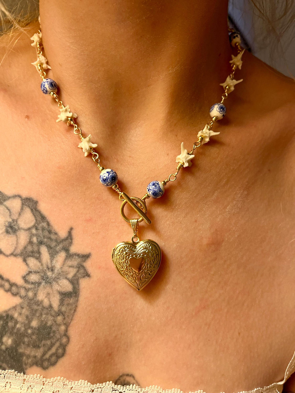 Rattlesnake Vertebrae Necklace with Blue Floral Ceramic Beads and Gold Plated Heart Locket | Toggle Closure – 16.5”